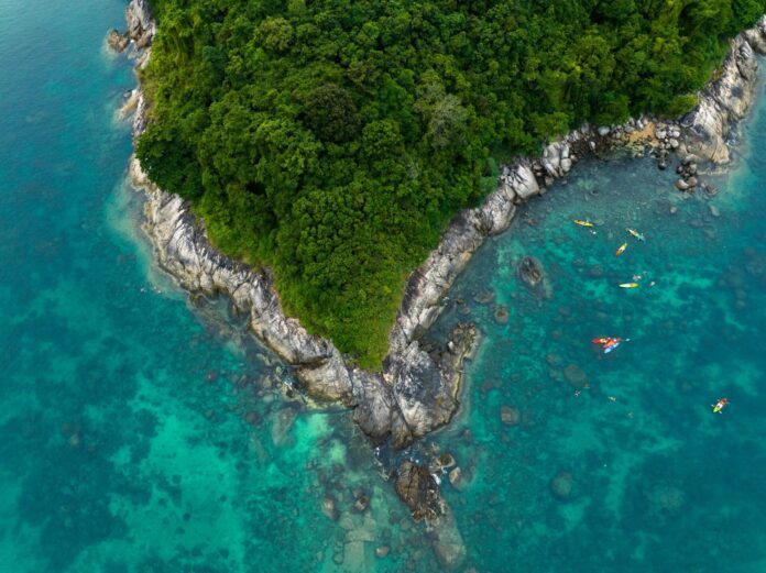 Aerial top view tourists kayaking, swimming and snorkeling at Koh Man island, Phuket, Thailand