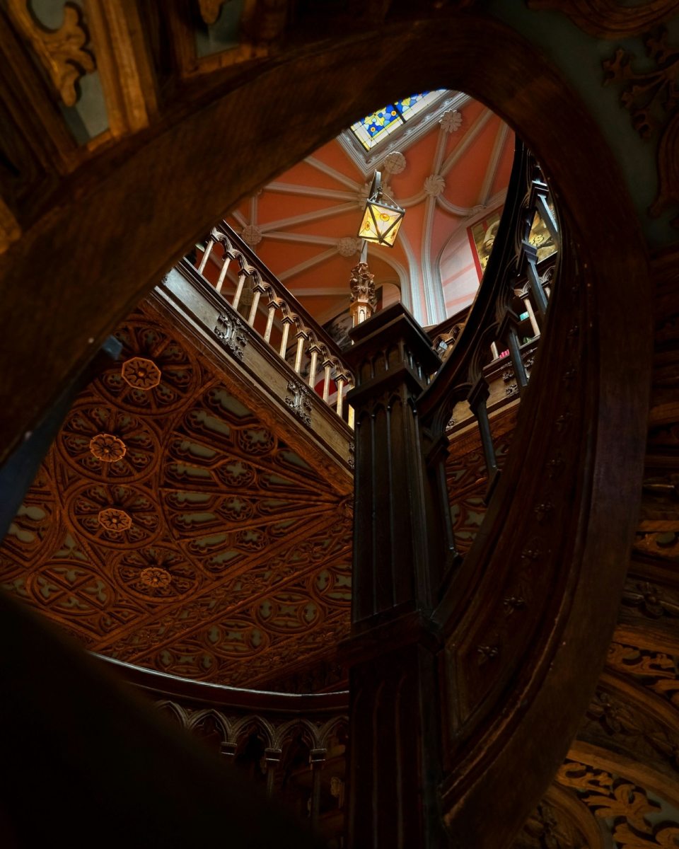 A wooden decorated spiral staircase inside the Livraria Lello in Porto, Portugal