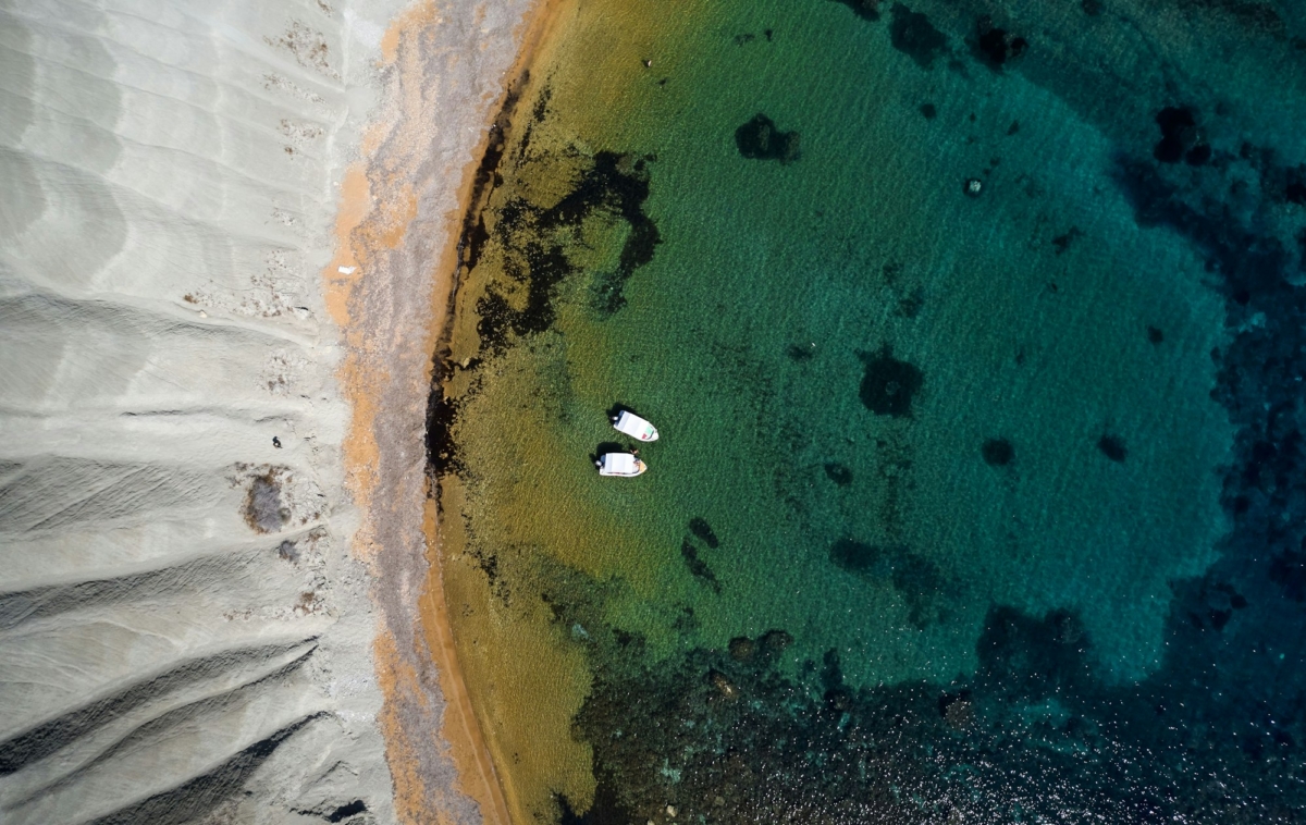 Aerial shot of Riviera Bay (Ghajn Tuffieha) with the rough waves and golden sand, in Malta