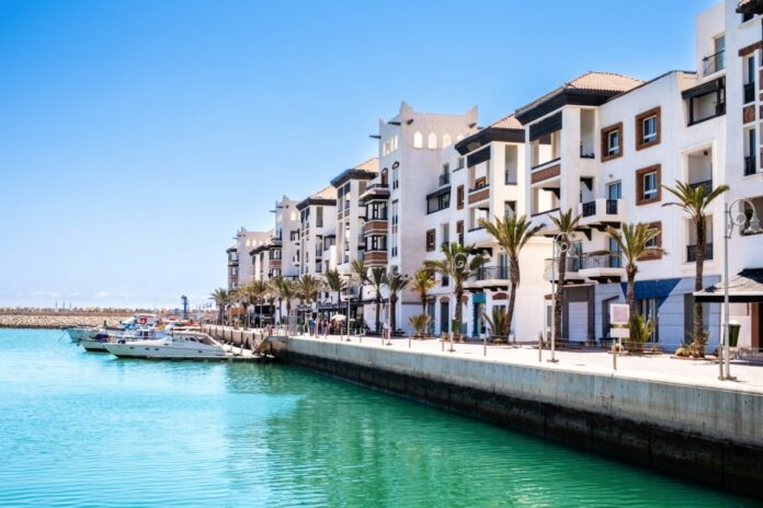 Agadir Marina with luxury apartments, boats in harbor, shops and restaurants.