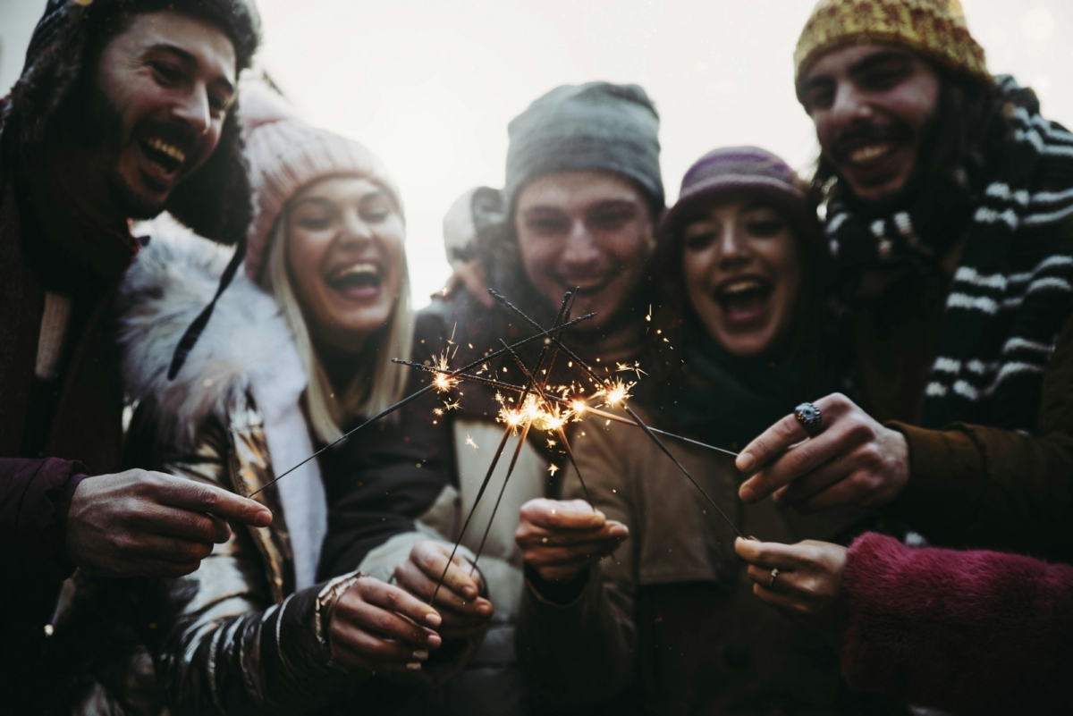 Happy friends celebrating new year eve with sparklers