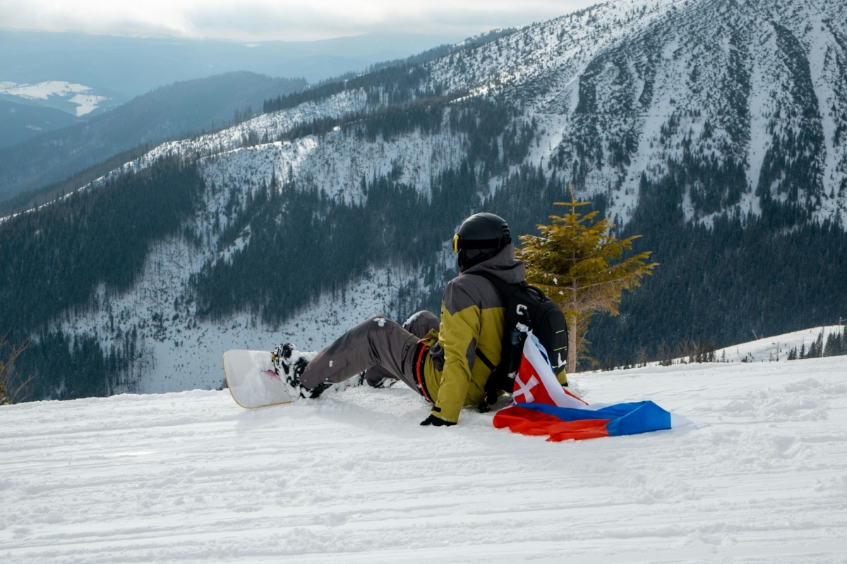 man snowboarder with slovakia flag at ski resort slope