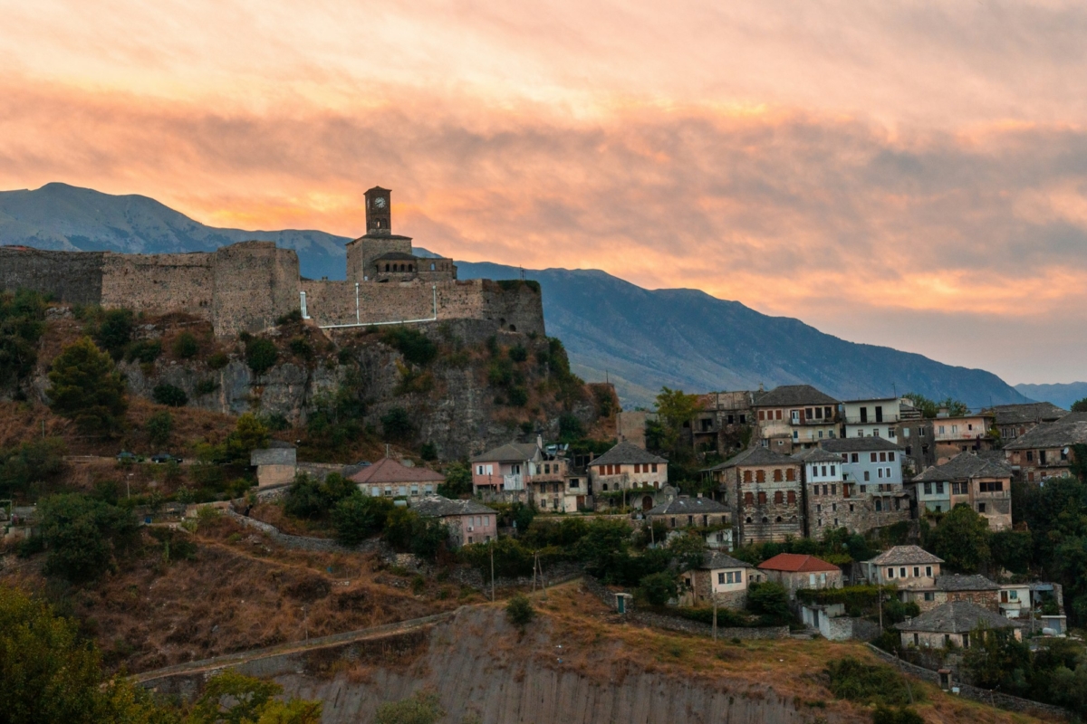 Sunset over the clock tower and Gjirokaster fortress, panoramic view of the city, Albania