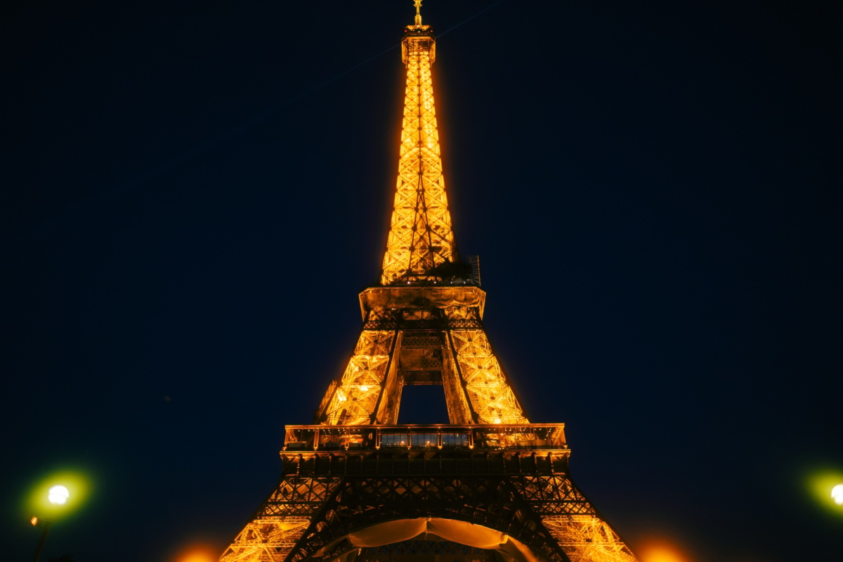 Glowing Eiffel Tower against the sunset sky in Paris, France.