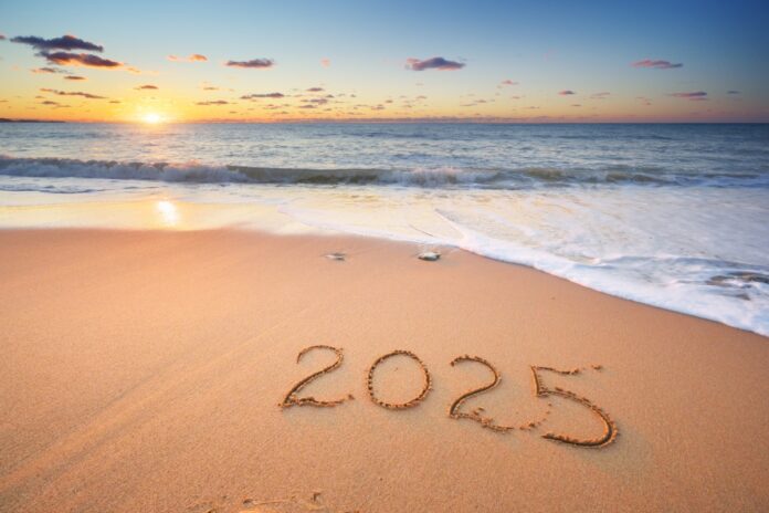 2025 text symbol of new year written on the seashore