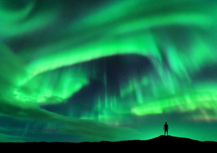 Aurora borealis and silhouette of standing man