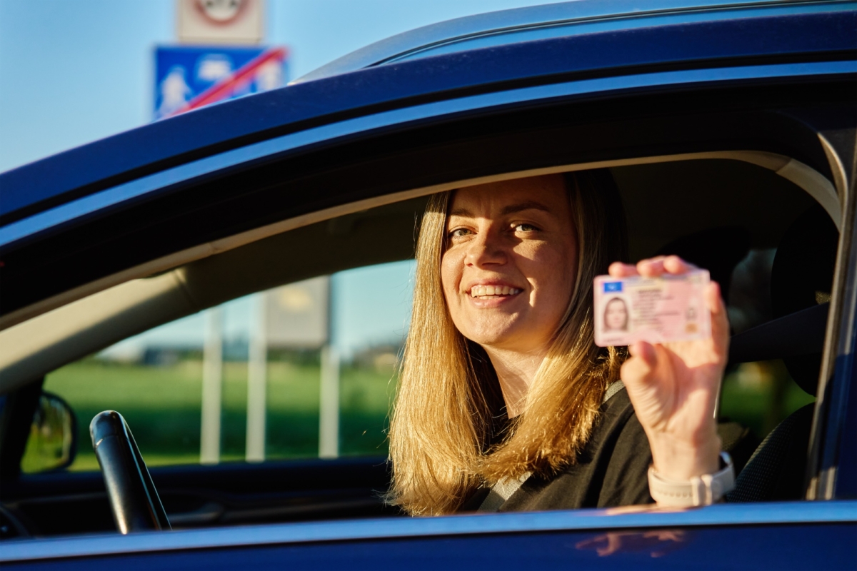 Happy Woman Holding Driver License in Car